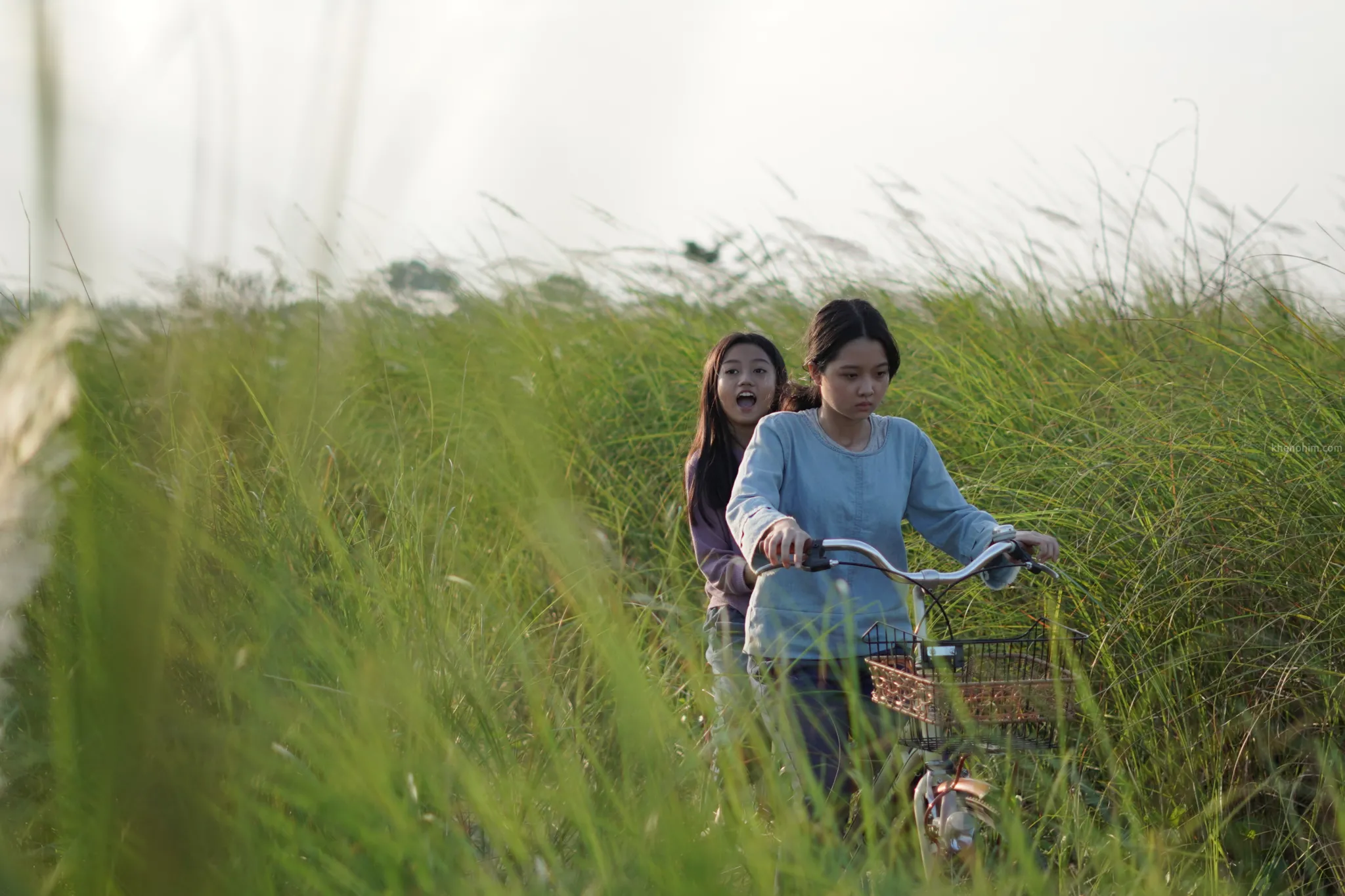 Linh (Lâm Thanh Mỹ - người lái xe đạp) và Yến (Mai Cát Vi) trong phim Bóng Đè