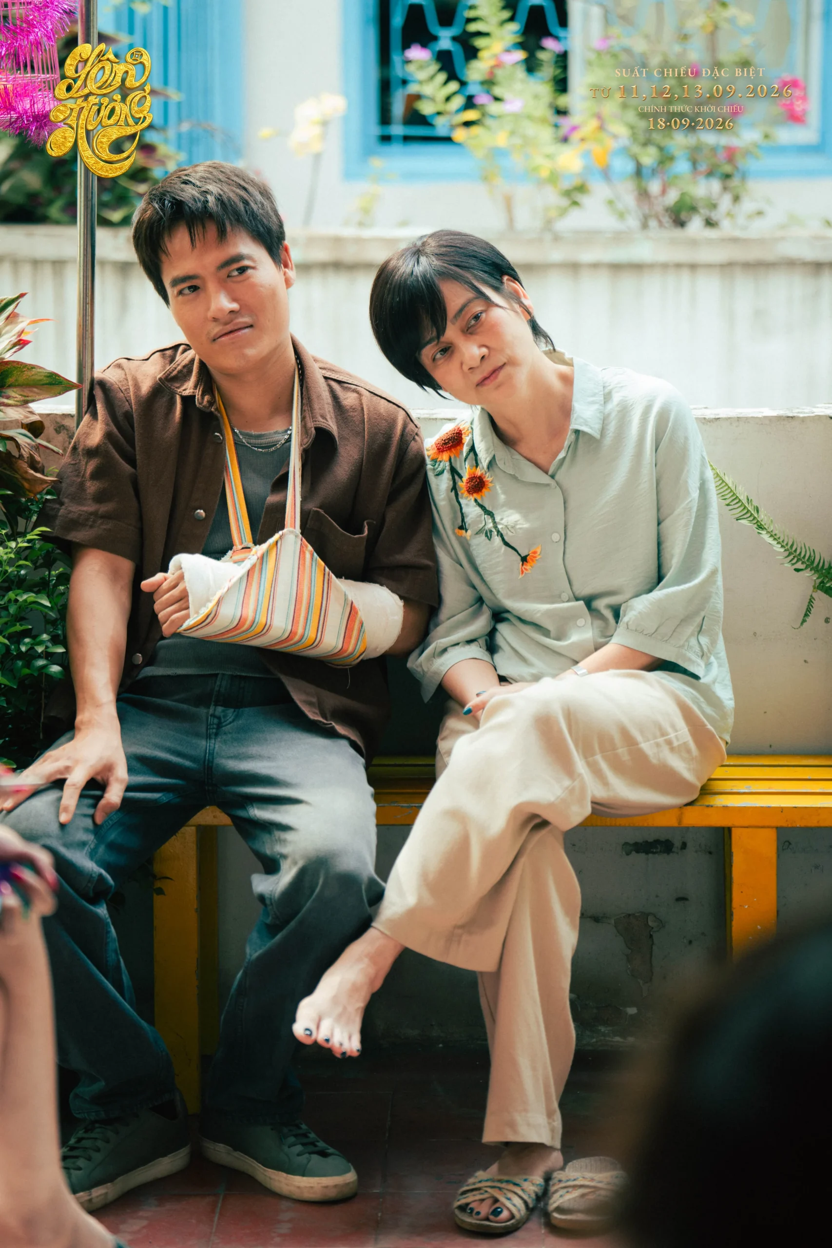 Võ Tấn Phát ngồi cạnh người phụ nữ, tay đeo băng vải sọc