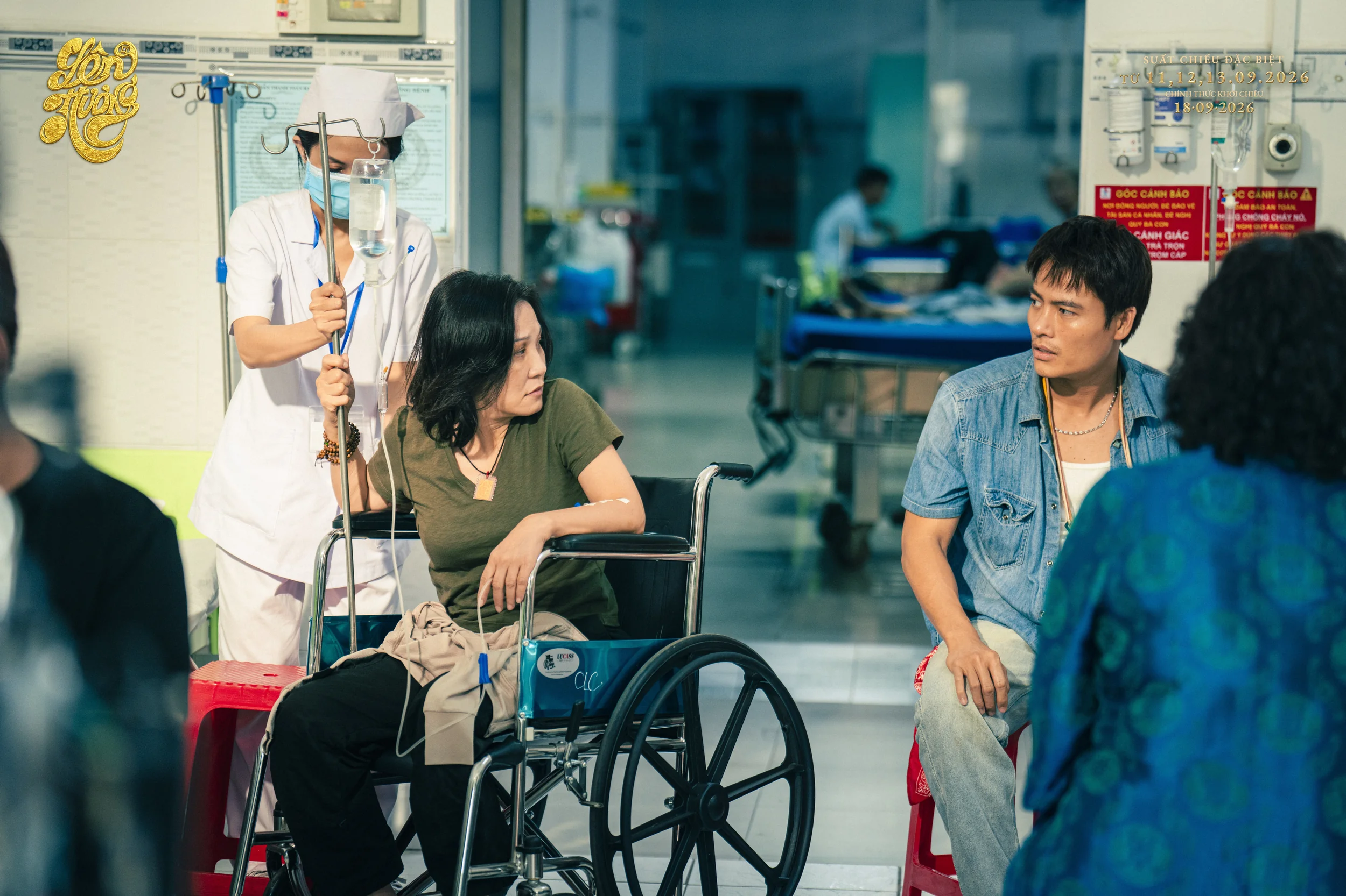 Võ Tấn Phát ngồi cạnh xe lăn trong hành lang bệnh viện